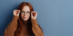 woman holding her glasses